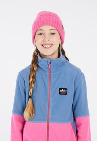 Blauwe en roze ritsfleecejack met hoge kraag, voorzien van een merkpatch en contrasterende rits. Roze gebreide muts met een textuurpatroon.
