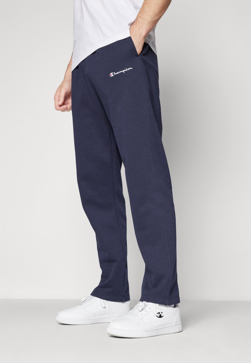 Pantalons de survêtement bleu marine en coton, dotés d'un logo sur la cuisse gauche, de poches latérales et d'une coupe décontractée avec des ourlets à poignets.
