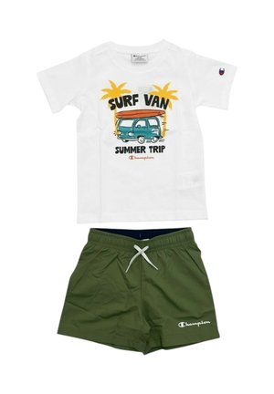T-shirt bianca con la scritta "Surf Van Summer Trip" e grafica di un furgone con palme, abbinata a pantaloncini verde oliva con coulisse e logo Champion.