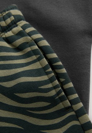 Grønt og beige stribet stof med et tigermønster sammen med et glat mørkegrå tekstil, begge med tydelige teksturer.