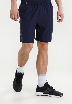 Marineblaue Sportshorts mit elastischem Bund und Seitentasche, kombiniert mit schwarzen Turnschuhen und weißen Kniestrümpfen. Glatte Textur und lockere Passform.