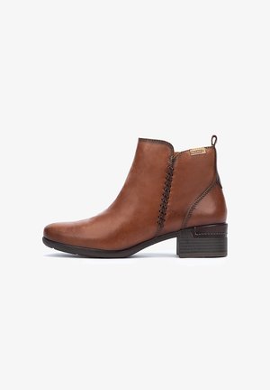 Bottes en cuir marron à cheville avec un bout rond, des détails de couture sur les côtés et un petit talon carré. Design minimaliste avec une finition lisse.