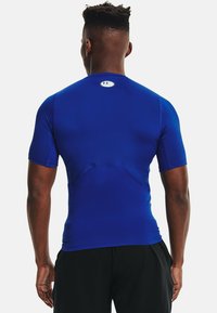 Korte mouwen sportshirt in levendig blauw, gemaakt van rekbaar materiaal. Heeft een ronde hals met een logodetail op de rug.