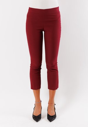 Pantaloni a vita alta in borgogna realizzati in tessuto elasticizzato con una texture liscia, dotati di una cintura aderente e un orlo appena sopra la caviglia.