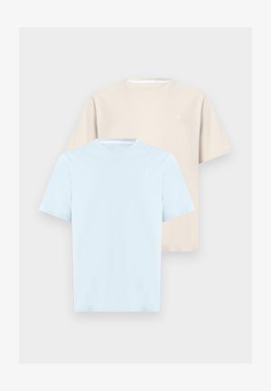 Dvě jednobarevná trička s krátkým rukávem a kulatým výstřihem, jedno světle modré vpředu a druhé béžové vzadu, vystavená na neutrálním pozadí.