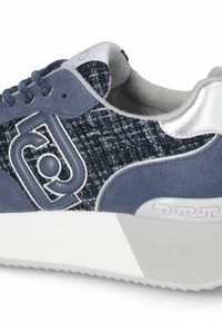 Sneaker blu con tomaia in tessuto texture, dettagli in suede, tacco metallico argento e suola in gomma bianca con un motivo geometrico unico.