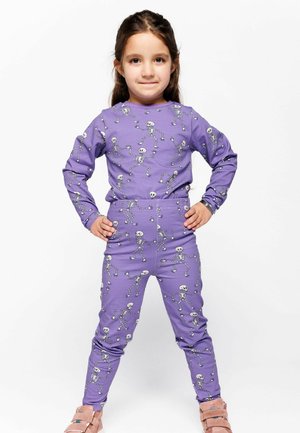 Purple pajama set with a skeleton pattern, made from soft fabric. Long sleeves and fitted pants with an elastic waistband.