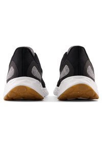 Schwarze Sportschuhe mit Obermaterial aus strukturiertem Stoff, grauen Akzenten und einer gepolsterten weißen Zwischensohle. Gummilaufsohle mit einem strukturierten Profil.