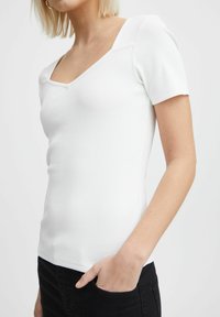 White ribbed short-sleeve top featuring a V-neckline and fitted design. The fabric has a smooth texture, suitable for casual wear.
