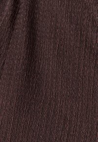 Textured brown fabric with a wavy pattern, featuring subtle variations in shade and a slightly coarse surface, ideal for various applications.