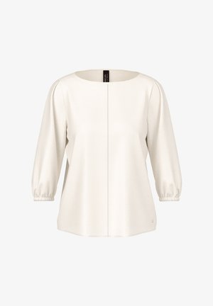Cream-colored blouse with three-quarter puffed sleeves, round neckline, and a vertical seam down the center front.