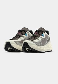 Αθλητικά παπούτσια Salomon με γκρι  και λευκό σχέδιο, υφασμένο επάνω μέρος, μαύρη εξωτερική σόλα και ρυθμιζόμενο σύστημα κορδονιών.