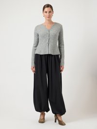 Γκρι ριμπ ζακέτα με μακριά μανίκια και κουμπιά, συνδυασμένη με μαύρο φαρδύ παντελόνι και καφέ ψηλοτάκουνα. Μινιμαλιστικός σχεδιασμός.