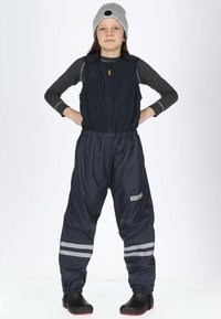 Marine vandtætte overalls med reflekterende striber, parret med en grå hue. Stoffet er glat; designet har lynlås og en praktisk pasform.