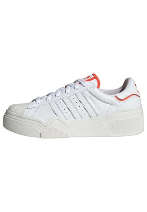 Biały niski sneaker z trzema przeszywanymi paskami, teksturowaną podeszwą i pomarańczowymi akcentami na pięcie i języku.