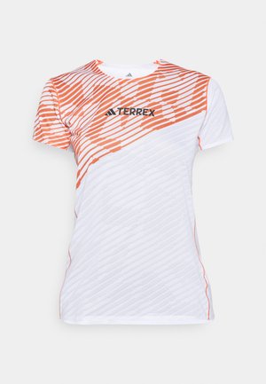 Bela in oranžna športna majica s kratkimi rokavi z diagonalnim črtastim vzorcem in logotipom "TERREX" čez prsi.