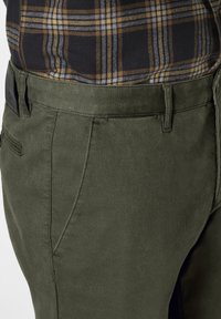 Olive green trousers made of textured fabric, featuring a tailored fit, straight leg, and a subtle side pocket design.