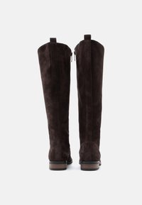 Mörkbruna mocka ankle boots med hög skafthöjd, sidodragkedjor och klack i staplad design. Enkelt utförande utan synliga mönster eller hårdvara.