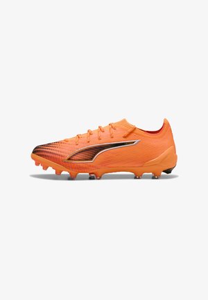 Crampons de football orange vif avec des détails noirs, des lacets et des crampons texturés pour un jeu sur sol dur.