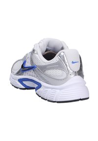 Scarpa sportiva argento e bianca con dettagli blu, tomaia in rete, colletto imbottito, suola texturizzata e logo Nike sul tallone e sul lato.