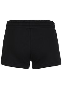 Shorts en coton noir avec une texture douce, une taille élastique et un design simple et dépouillé. La vue de dos montre la finition lisse des shorts.