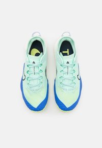 Chaussures de sport bleu clair avec tige en mesh, accents jaunes et bleu marine, et semelles texturées bleues. Dotées de lacets plats et d'un col rembourré.