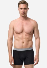 Schwarze Boxer-Shorts mit einem grauen elastischen Bund. Die Shorts bestehen aus einem glatten Stoff, haben ein körpernahes Design und sind in mittellanger Länge bis zum Oberschenkel.