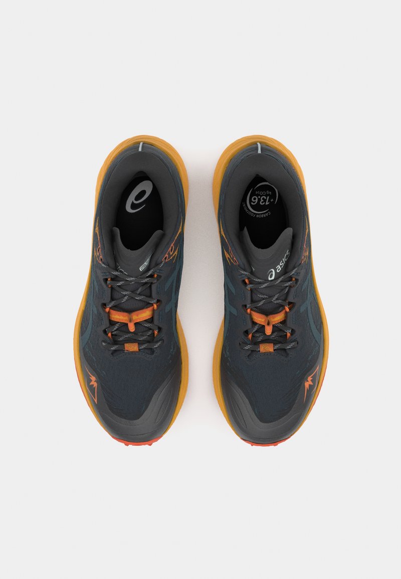 Baskets de sport grises avec des accents orange, tige texturée, bout renforcé et semelle en caoutchouc flexible. Les lacets et le logo présentent des détails réfléchissants.