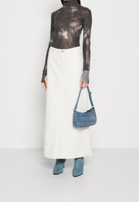 Valkoinen farkku maxi-hame, harmaa sitruunadye painatuksella varustettu pitkähiha, sininen lyhyt käsilaukku ja siniset nilkkurit. Keskitytään materiaaleihin ja väreihin.