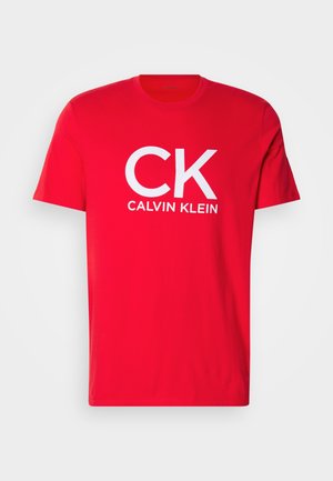 T-shirt rossa in cotone con una grande stampa bianca "CK" e "CALVIN KLEIN". Maniche corte e design classico con collo a giro. Tessuto liscio.
