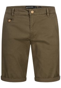 Shorts en coton vert olive avec une texture lisse, ourlets retournés, fermeture par bouton et poches avant. Les caractéristiques sont minimales et pratiques.