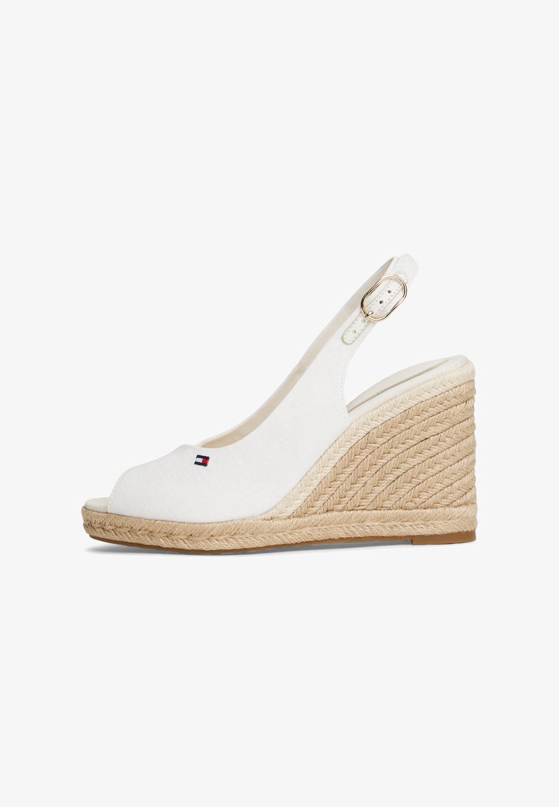 Sandale compensée en toile blanche avec bout ouvert, semelle enveloppée de jute et bride à la cheville avec boucle dorée. Petit logo sur le bout.