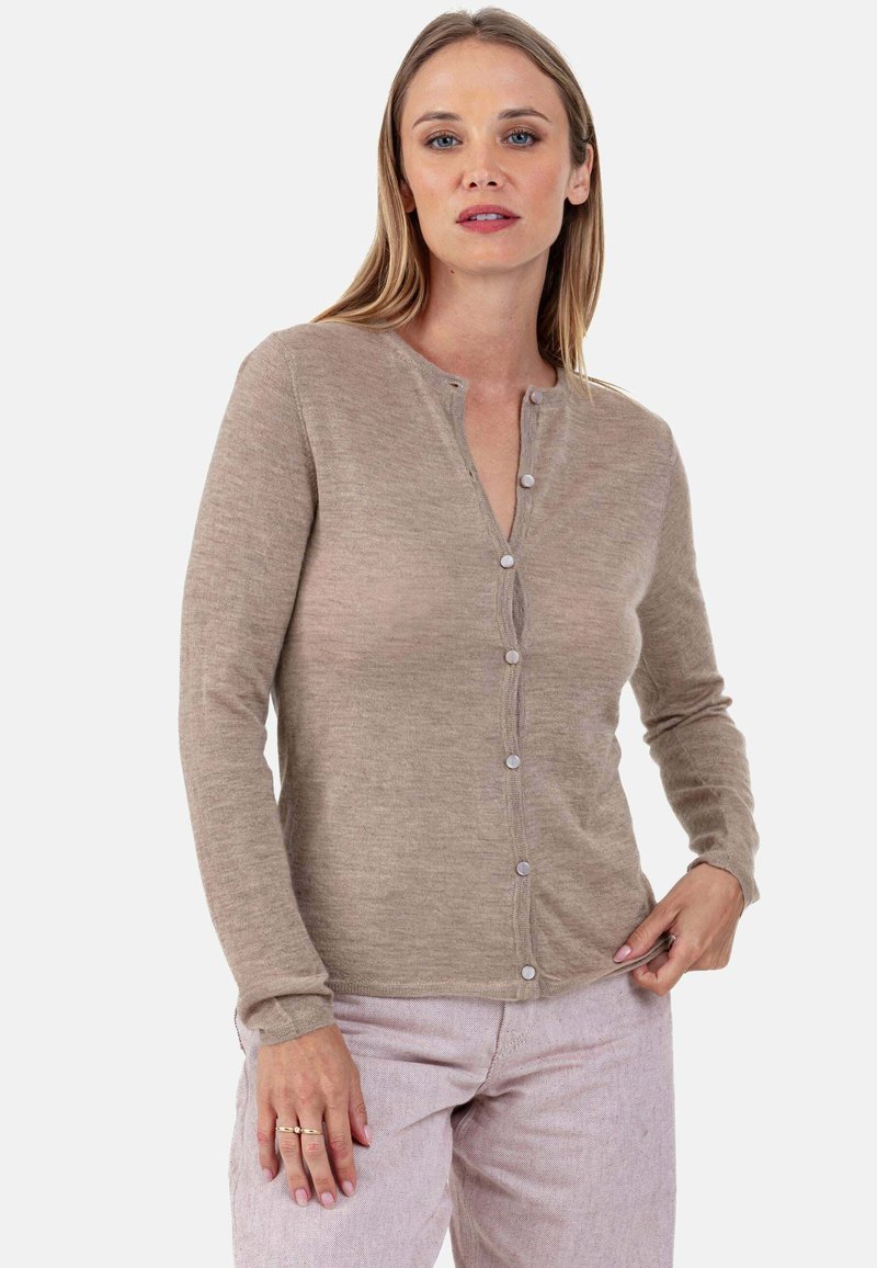 Cardigan à manches longues beige clair avec un col rond, une fermeture à boutons sur le devant et une texture douce. Détail de couture subtil le long des bords.