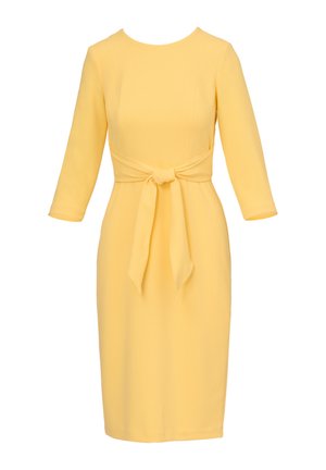 Geel knielang jurkje met driekwart mouwen en een stoffen ceintuur gestrikt in een strik in de taille.