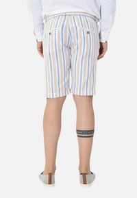 Pantaloni corti leggeri a righe in beige, azzurro chiaro e bianco, con vita regolabile con cordino, tasche posteriori con dettagli a bottone e una vestibilità casual.