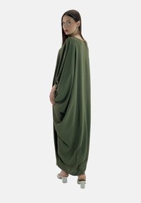 Vestito lungo di colore verde oliva, largo e morbido, con maniche drappeggiate. Tessuto liscio, design minimale e colletto rotondo.