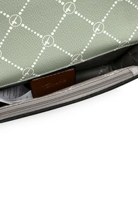 Zielona torebka z fakturowanej skóry z białym geometrycznym wzorem. Wnętrze ma szare podszycie oraz zasuwaną kieszeń do bezpiecznego przechowywania.