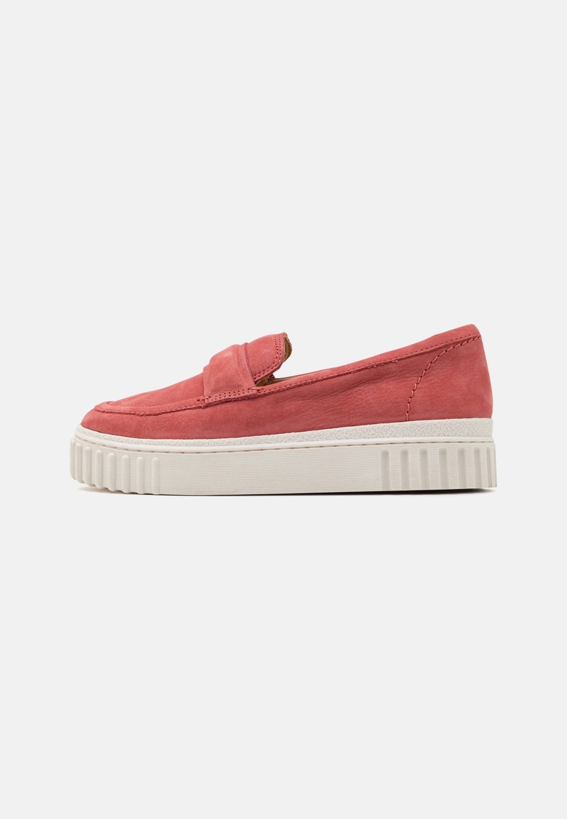 Des chaussures slip-on en suede de couleur corail rose, avec une bande rembourrée et une épaisse semelle en gomme blanche à motifs striés.