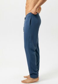 Marineblauwe joggingbroek van zachte stof, met een elastische tailleband met trekkoord, zijzakken en taps toelopende pijpen.