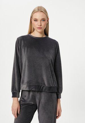 Grå velour sweatshirt med lange ærmer, ribbede manchetter og rund halsudskæring. Stoffet har en glat, blød overflade og en let glans.