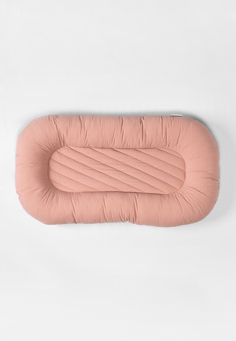 Coussin pour animaux rectangulaire en tissu rose doux, avec une texture matelassée et des bords surélevés pour le soutien. Convient à différentes tailles d'animaux.