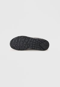 Semelle de chaussure en caoutchouc noir avec un motif de grip texturé. Présente une base large et des rainures définies pour l'adhérence. Transitions d'arêtes lisses.