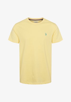 Dzeltena kokvilnas t-kreklu ar apaļu kakla izgriezumu. Iekļauta maza zaļa logo kreisajā krūtī un īsās piedurknes. Mīksts audums, neformīga piegriezte.