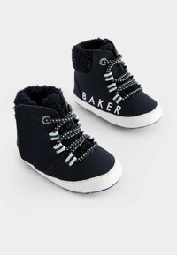 Zapatos de bebé de caña alta azul marino con suelas de goma blanca, con un collar suave, cordones a rayas y el texto "BAKER" en el lateral.