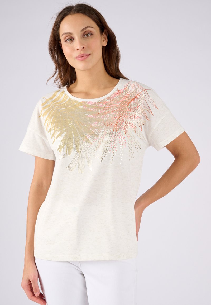 Katoenen t-shirt in een lichtcrème kleur, met een gouden en koraalkleurige bladmotiefdetail aan de linkerkant. Korte mouwen en een ronde halsontwerp.