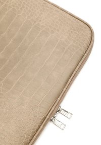 Beige laptop sleeve med krokodilleskinds mønster. Fremstillet af tekstureret materiale med dobbelt sølv lynlås og stikninger i kanterne.