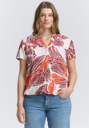 Blouse à manches courtes avec un motif floral rouge et orange sur fond blanc, dotée d'un col en V et d'une coupe décontractée.