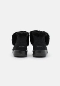 Sorte ankelboots i semsket skinn med faux fur-kant, strukturert overflate, flat gummisåle og logo detalj bak. Ideelle for hverdagsbruk.