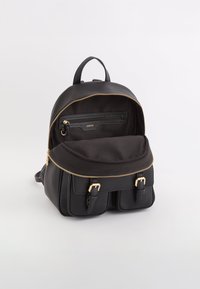 Sac à dos noir en cuir texturé avec fermeture éclair, doté d'une fermeture éclair dorée, d'une poche intérieure et de deux sangles avant.