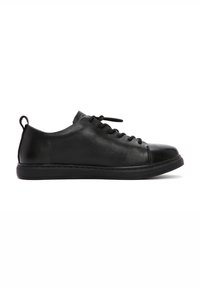 Sneaker in pelle nera con forma arrotondata, design con lacci e finitura testurizzata. Presenta una suola in gomma a profilo basso e un tab per il tallone.